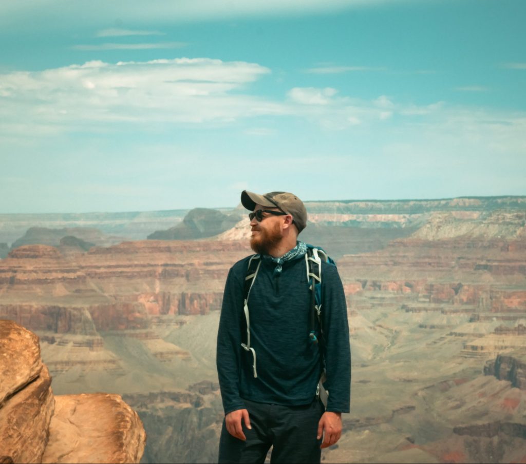 Image of man standing before the Grand Canyon, looking to the left